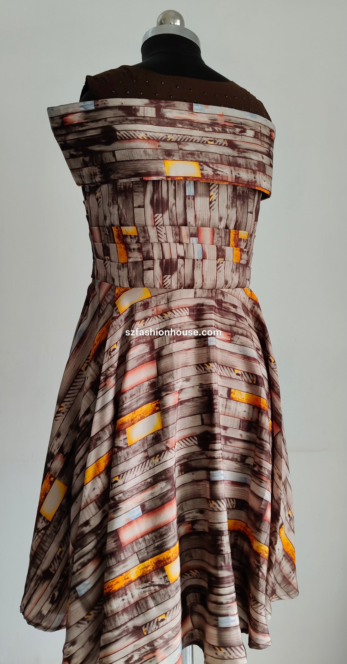 Mannequin wearing a patterned dress with a plain background
